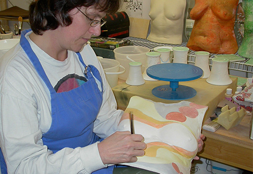 Cheryl-Ann Webster decorates one of the Beautiful Women Project sculptures